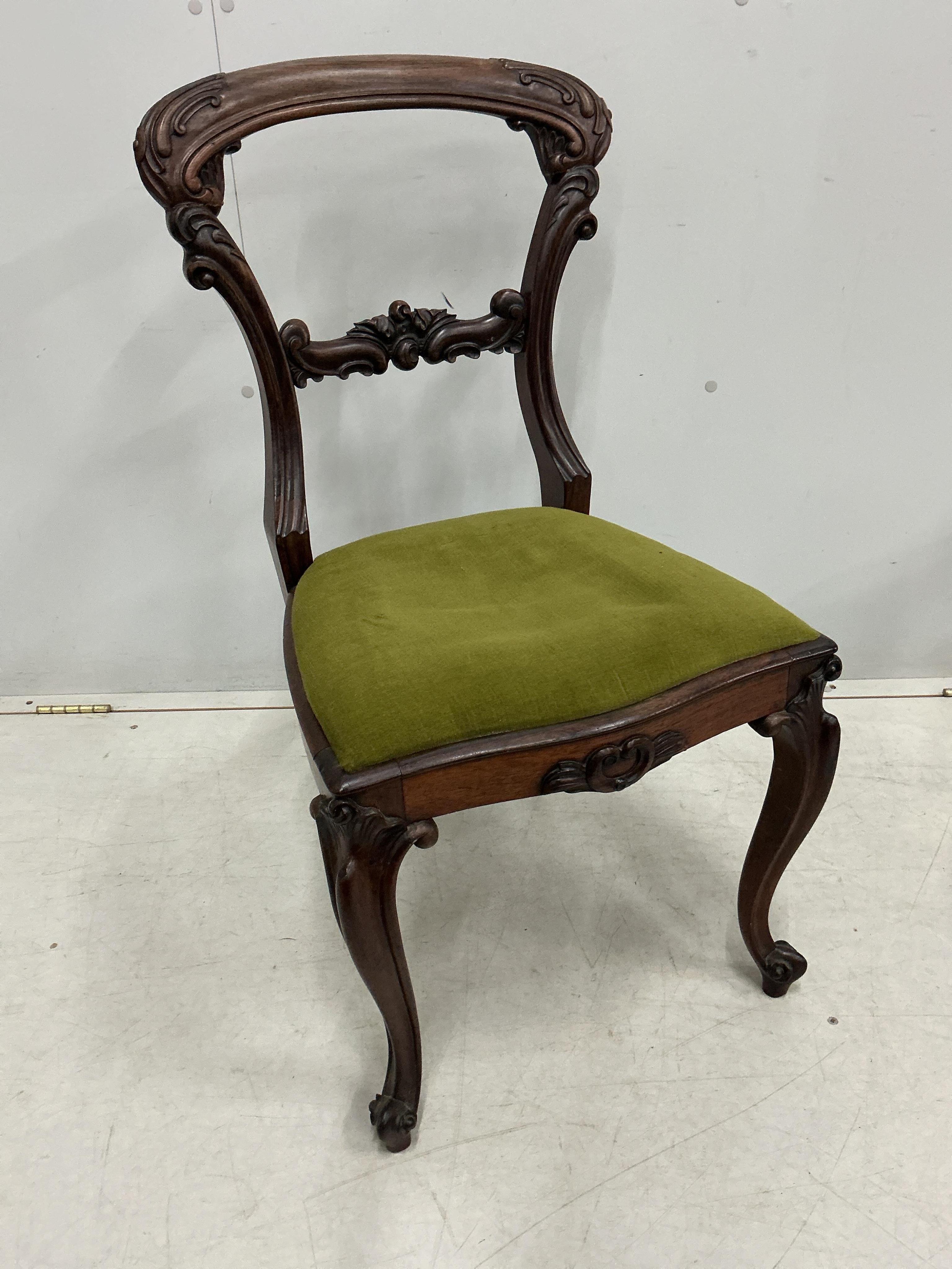 A set of four early Victorian rosewood balloon back dining chairs, height 86cm